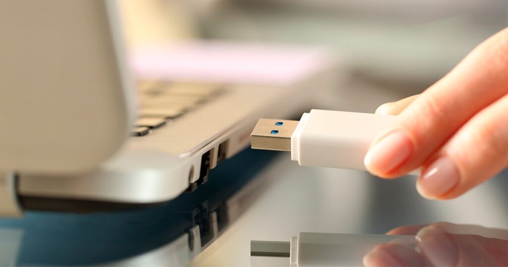 Una persona conectando una memoria USB